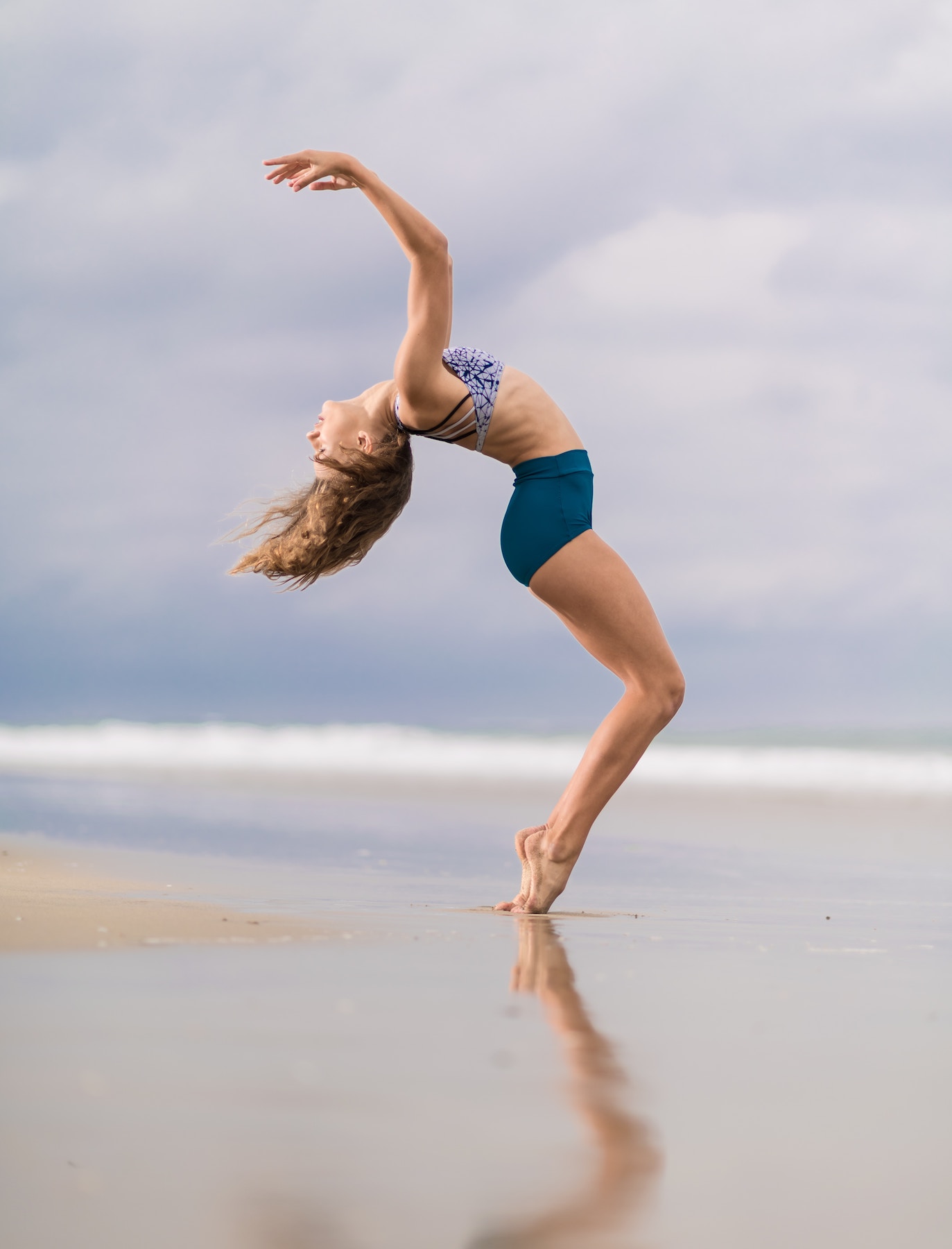 Frau, welche am Strand Yoga macht